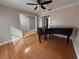 Open living room with hardwood floors, a piano, ceiling fan, and lots of natural light at 11708 Nicklaus Cir, Tampa, FL 33624