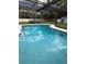 Sparkling pool with screened enclosure, complemented by a vintage pickup truck adding character to the backyard at 11708 Nicklaus Cir, Tampa, FL 33624