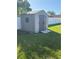 Backyard storage shed with double doors offers ample storage for lawn equipment, tools, and outdoor essentials at 11708 Nicklaus Cir, Tampa, FL 33624