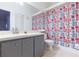 This bathroom offers a single vanity, colorful shower curtain, and a tiled floor at 11868 Skylake Pl # 11767, Temple Terrace, FL 33617