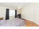 A cozy bedroom with a ceiling fan, a large window, and wood-look flooring at 11868 Skylake Pl # 11767, Temple Terrace, FL 33617