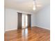 A bedroom with hardwood floors, a ceiling fan, and a french door that provides plenty of sunlight at 11868 Skylake Pl # 11767, Temple Terrace, FL 33617
