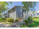 Attractive condo complex with mature landscaping, grey siding, stairs to the units, and a charming, welcoming appeal at 11868 Skylake Pl # 11767, Temple Terrace, FL 33617