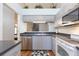 This kitchen features gray cabinets, stainless steel appliances, and a decorative shelf above the cabinets at 11868 Skylake Pl # 11767, Temple Terrace, FL 33617