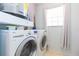 This laundry room includes a washer, dryer, and a window for natural light at 11868 Skylake Pl # 11767, Temple Terrace, FL 33617