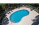 Aerial view of a kidney-shaped community pool with surrounding lounge chairs and a secure fence at 11868 Skylake Pl # 11767, Temple Terrace, FL 33617