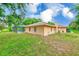 Exterior side view of a house showcasing the screened pool enclosure and a well-maintained lawn at 12302 Knight Pl, Thonotosassa, FL 33592