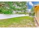 Large backyard with white fence, side view of house and screened pool enclosure at 12302 Knight Pl, Thonotosassa, FL 33592