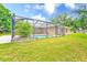This backyard features a screened-in in-ground pool and a spacious lawn area at 12302 Knight Pl, Thonotosassa, FL 33592