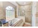 Luxurious bathroom features a soaking tub, glass-enclosed shower, and decorative tile accents at 12302 Knight Pl, Thonotosassa, FL 33592