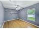 This bedroom offers hardwood floors, a ceiling fan, floating shelves, and a window with natural light at 12302 Knight Pl, Thonotosassa, FL 33592