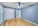 Bedroom with hardwood floors, blue painted walls, a ceiling fan, and a closet with sliding doors at 12302 Knight Pl, Thonotosassa, FL 33592