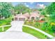 Beautiful single-story home with a three-car garage, well-manicured lawn, and mature landscaping at 12302 Knight Pl, Thonotosassa, FL 33592