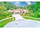 Attractive front exterior featuring a well-maintained yard, circular drive, and a two-car garage at 12302 Knight Pl, Thonotosassa, FL 33592