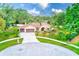 Attractive front exterior featuring a well-maintained yard, circular drive, and a two-car garage at 12302 Knight Pl, Thonotosassa, FL 33592