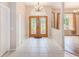 Bright foyer boasts tiled flooring, transom window, and double entry doors leading to the dining area at 12302 Knight Pl, Thonotosassa, FL 33592