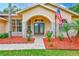 Inviting front entrance with double doors, brick accents, mulch beds and lush greenery at 12302 Knight Pl, Thonotosassa, FL 33592