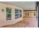 Covered patio with brick flooring and multiple doors leading inside the house at 12302 Knight Pl, Thonotosassa, FL 33592