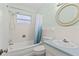 Bright bathroom featuring a tub with shower, a blue-topped vanity and tiled walls at 1411 Barry St, Clearwater, FL 33756