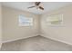 View of empty bedroom with a ceiling fan, two windows and carpet flooring at 1411 Barry St, Clearwater, FL 33756