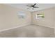 View of empty bedroom with a ceiling fan, two windows and carpet flooring at 1411 Barry St, Clearwater, FL 33756