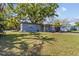 Charming single-story home featuring a well-maintained lawn and mature trees providing ample shade at 1411 Barry St, Clearwater, FL 33756