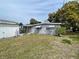 Backyard view of gray home, featuring a grassy lawn and gray exterior siding at 14616 Coral Dr, Hudson, FL 34667