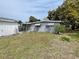 Backyard view of gray home, featuring a grassy lawn and gray exterior siding at 14616 Coral Dr, Hudson, FL 34667