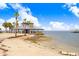 Stunning beach with a covered pavilion, palm trees, and tranquil water views for relaxing coastal living at 14616 Coral Dr, Hudson, FL 34667
