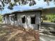 Side exterior view of a gray home, featuring a fenced yard and a covered carport at 14616 Coral Dr, Hudson, FL 34667