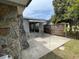 Outdoor patio with rock detail home, fenced yard, and tree at 14616 Coral Dr, Hudson, FL 34667
