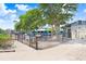 Playground with swings and climbing equipment, fenced for safety and surrounded by trees at 14616 Coral Dr, Hudson, FL 34667