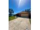 Brick home boasting an attached garage, driveway, and a spacious green lawn at 1850 Oklahoma Ne Ave, St Petersburg, FL 33703