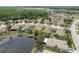 Aerial view of homes on a pond, some with pools, in a neighborhood with mature trees at 19123 Sunset Bay Dr, Land O Lakes, FL 34638