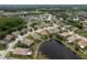 Aerial view of a neighborhood with homes located on a pond and lush green landscaping at 19123 Sunset Bay Dr, Land O Lakes, FL 34638