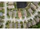 An aerial view of homes in a suburban neighborhood with well-manicured lawns and a pond at 19123 Sunset Bay Dr, Land O Lakes, FL 34638