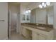 Bathroom featuring dual sinks with granite countertops, decorative lighting, and large mirror at 19123 Sunset Bay Dr, Land O Lakes, FL 34638