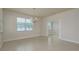 Dining area with tile floors features a modern chandelier and a large window overlooking the property at 19123 Sunset Bay Dr, Land O Lakes, FL 34638