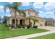 Charming two-story home boasts a well-manicured lawn, complemented by lush landscaping and a three-car garage at 19123 Sunset Bay Dr, Land O Lakes, FL 34638