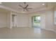 Spacious living room features tile flooring, ceiling fan, and sliding glass door to patio at 19123 Sunset Bay Dr, Land O Lakes, FL 34638