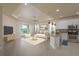 Open-concept living room and kitchen features neutral tile flooring, pendant lights and granite countertops at 19123 Sunset Bay Dr, Land O Lakes, FL 34638