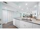 Open kitchen featuring white cabinets, stainless steel appliances, stone countertops, and view to the living area at 19531 Gulf Blvd # 404, Indian Shores, FL 33785