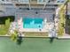 Aerial view of a community pool and waterfront, with lounge chairs surrounding and lush landscaping at 200 Brightwater Dr # 10, Clearwater Beach, FL 33767