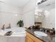 Bathroom featuring a jacuzzi tub, granite countertop, decorative accents, and bright tile throughout the interior at 200 Brightwater Dr # 10, Clearwater Beach, FL 33767
