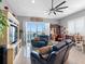 Bright living room featuring tile floors, modern ceiling fan, water view, and comfortable furniture at 200 Brightwater Dr # 10, Clearwater Beach, FL 33767