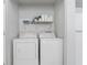 Bright laundry room with white washer and dryer and storage shelves at 217 Regal Park Dr, Valrico, FL 33594