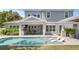 Relax in this backyard featuring a pool with loungers, an outdoor kitchen, and lush landscaping at 2316 S Thixton Ct, Tampa, FL 33629