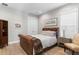 Cozy bedroom with a leather sleigh bed, wood floors, and bright natural light at 2316 S Thixton Ct, Tampa, FL 33629