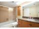 A bathroom with a combined bathtub and shower, a toilet, and a light wood vanity with a granite countertop at 2599 Dolly Bay Dr # 209, Palm Harbor, FL 34684