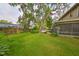 Well maintained backyard with green lawn, pool, mature trees, and screened in porch at 2812 Ormandy Ct, Tampa, FL 33618